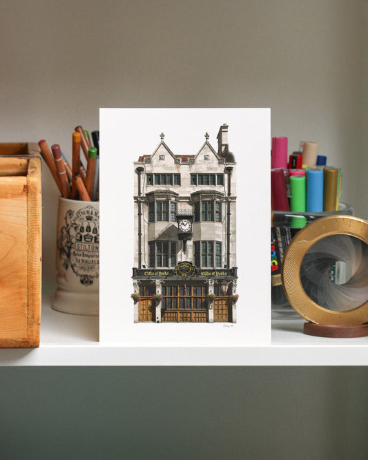 Print of The Cittie of York pub on a desk with stationery items.