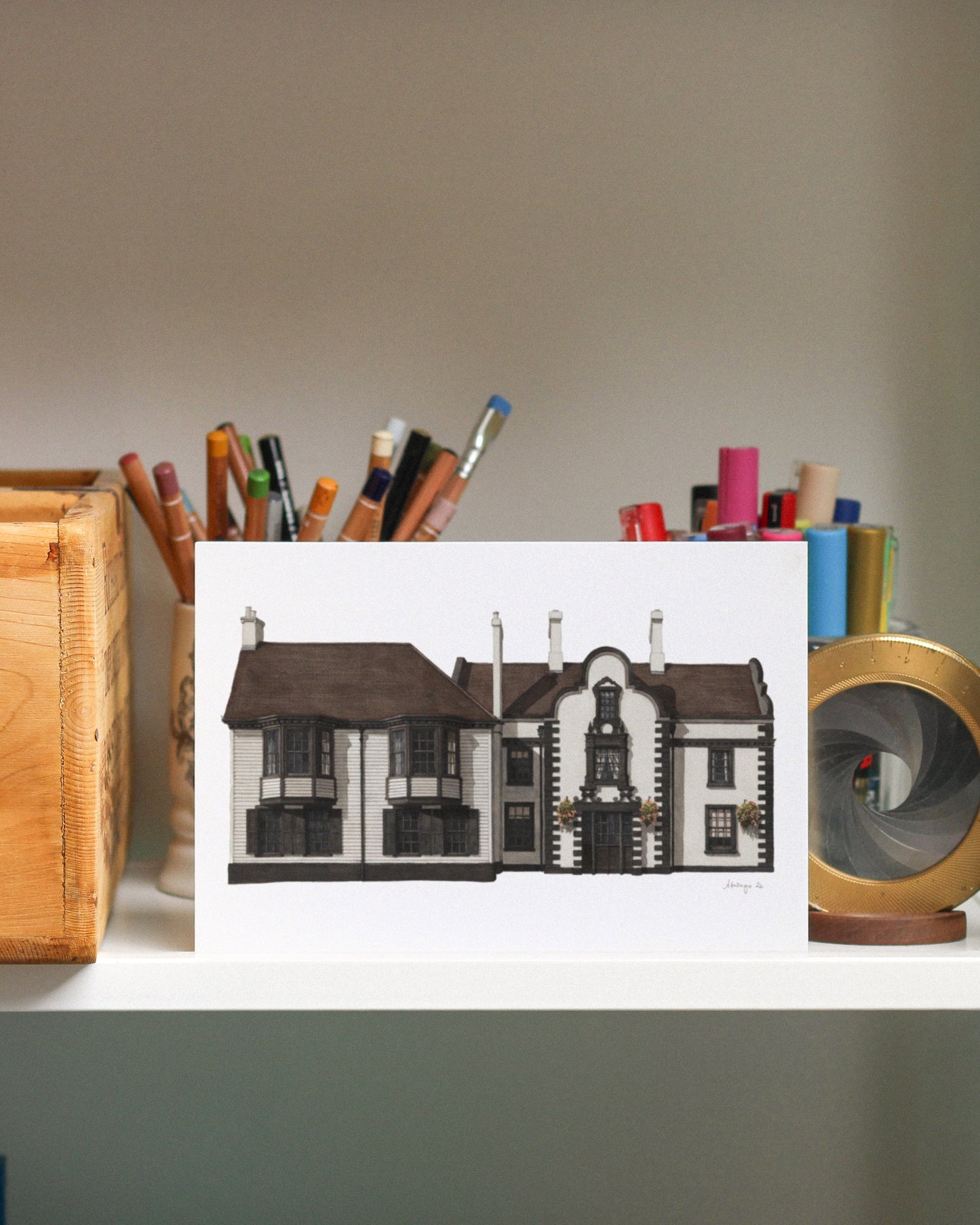 Art print of a house on a desk with stationery items