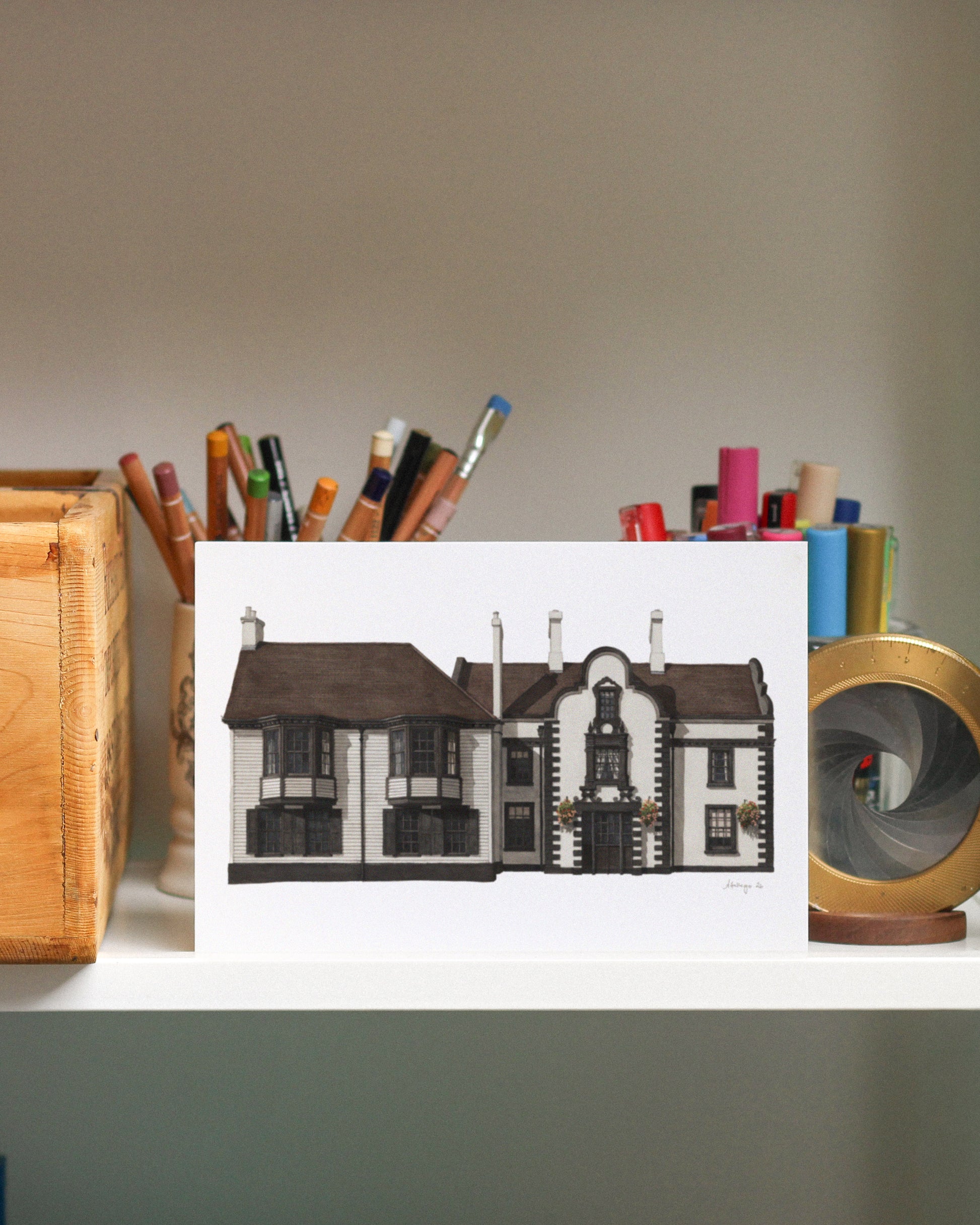 Art print of a house on a desk with stationery items
