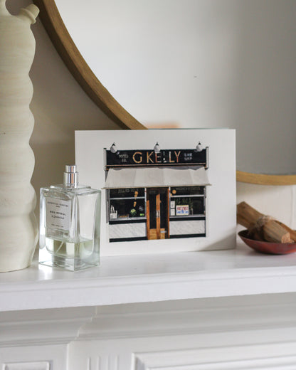 Perfume bottle and unframed picture on a mantelpiece with decorative items.