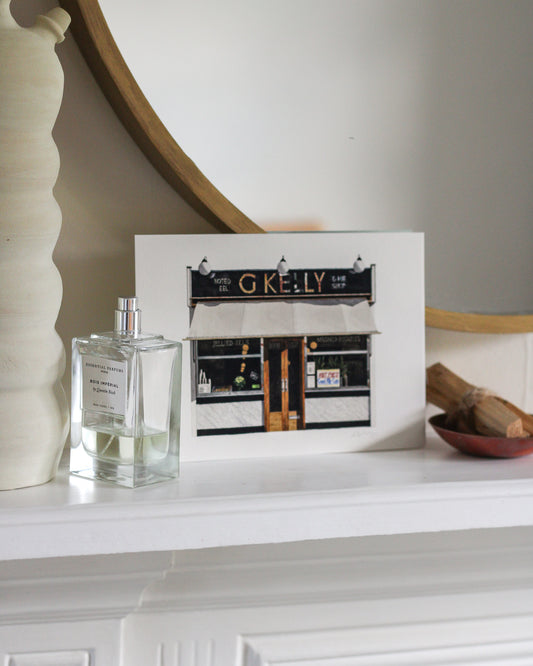 Perfume bottle and unframed picture on a mantelpiece with decorative items.