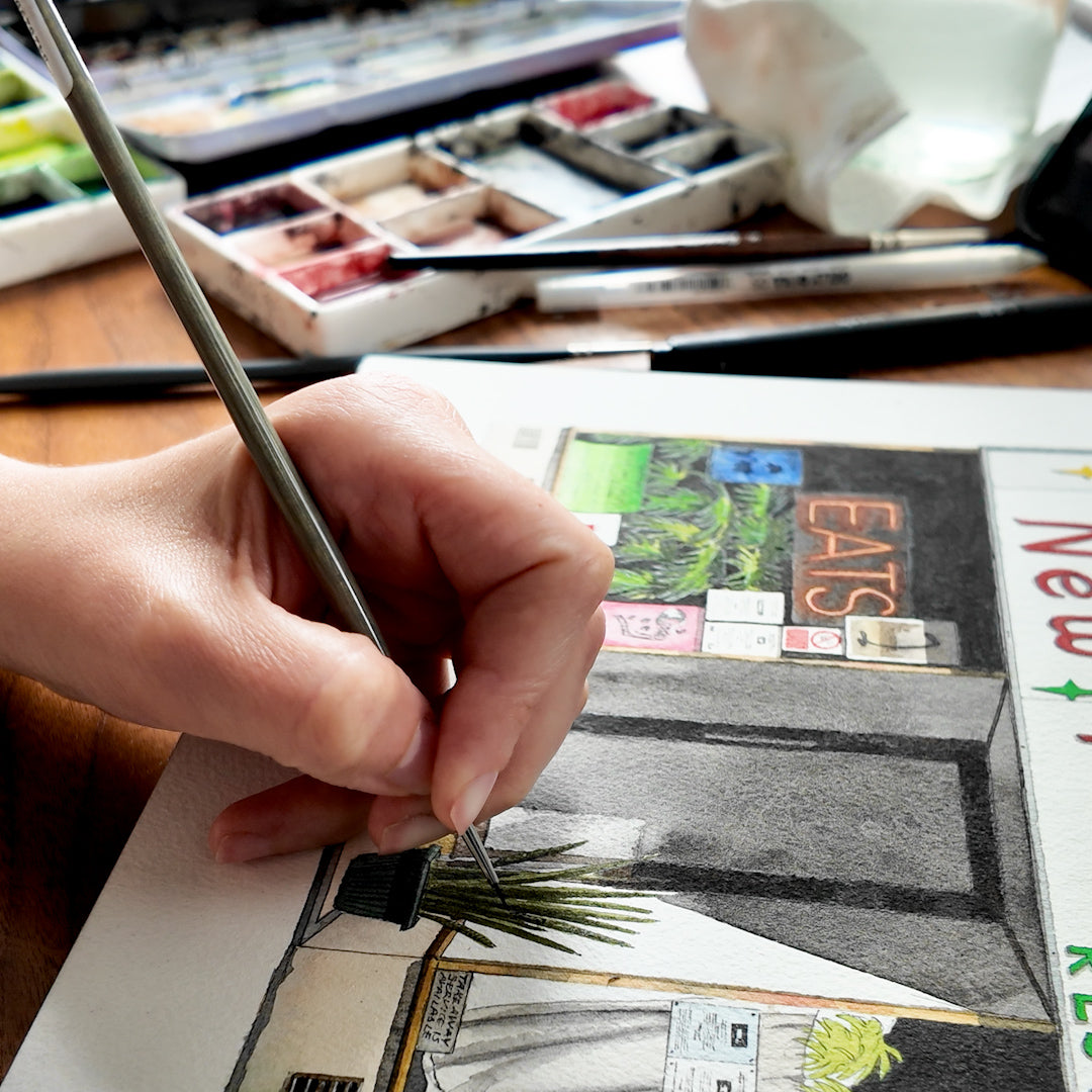 Ana Gallego painting a high street building