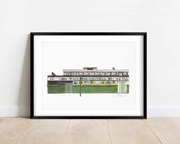 Watercolour giclée print of the Windmill pub, Brixton, shown in a black frame against a white wall.